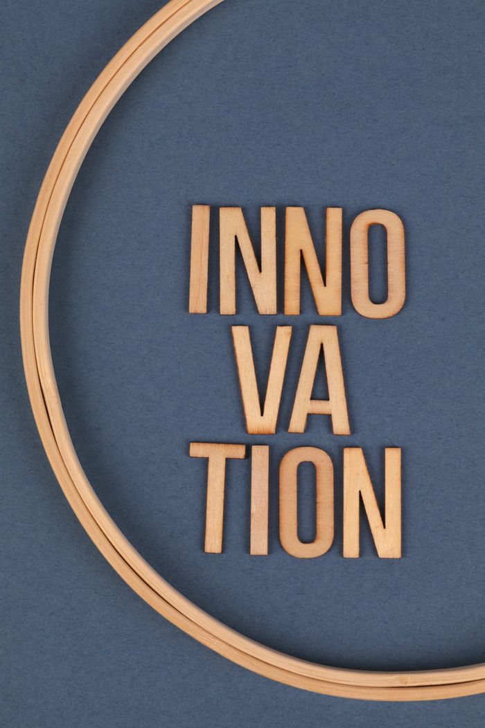 Close-up of wooden letters spelling innovation on a blue background.